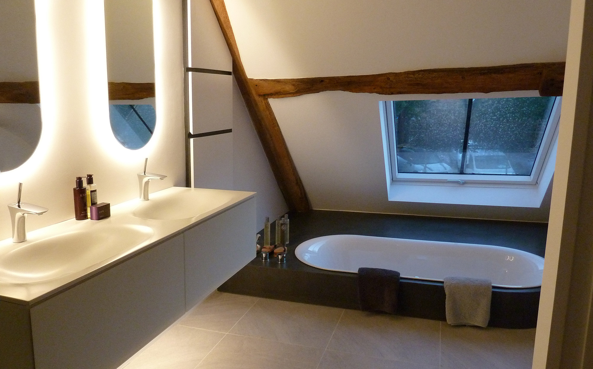 Bespoke bathroom with floor recessed bath and custom fabricated mirrors